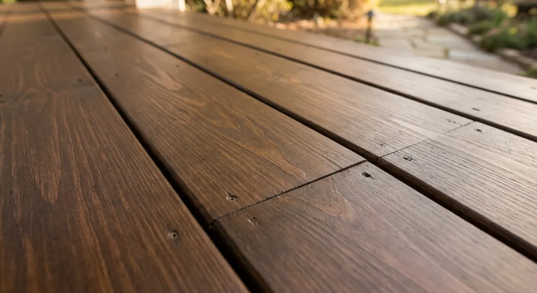 Wood deck floor sealed with penetrating stain, showing the grain and rich color