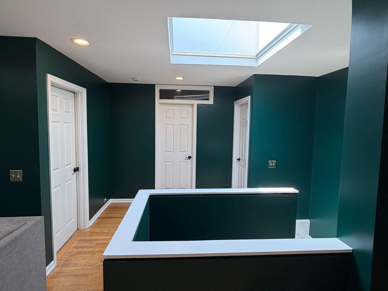 Living room angle showing skylight and green walls
