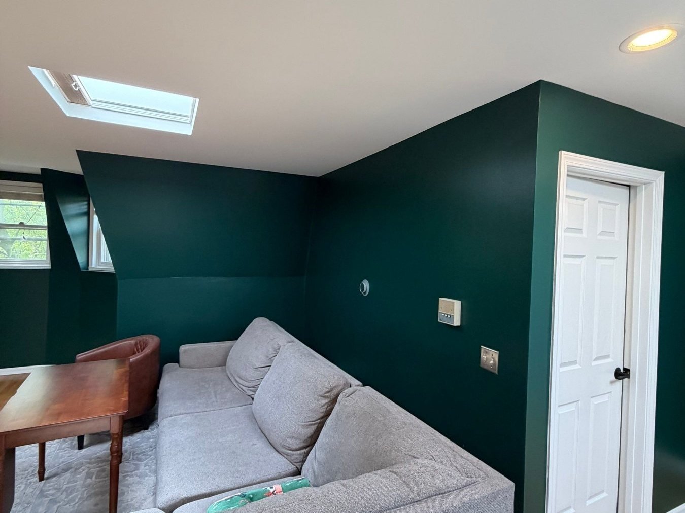 Sofa corner against deep green walls